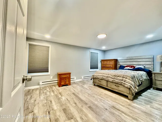 a bedroom with a large bed and a lamp on dresser