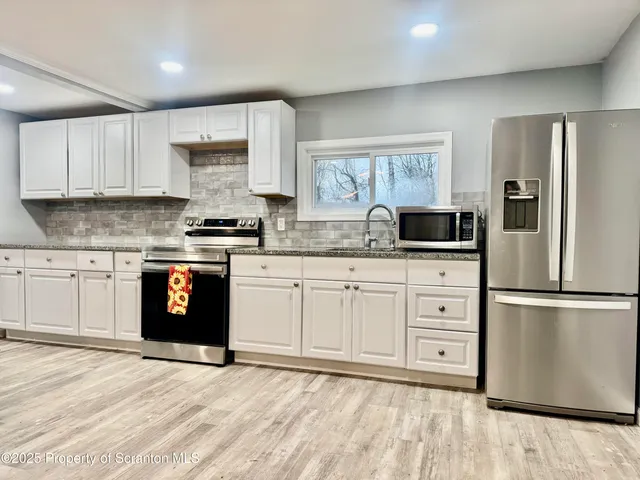 a kitchen with stainless steel appliances granite countertop a refrigerator sink and cabinets