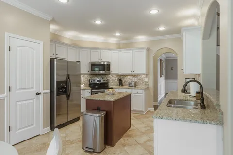 a kitchen with a refrigerator a sink and cabinets
