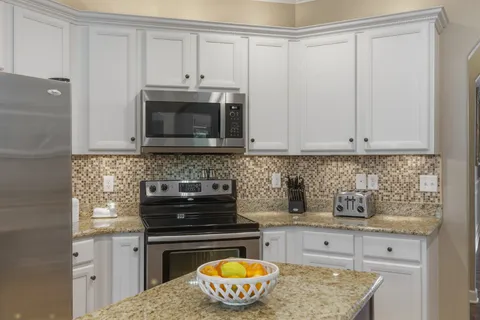 a kitchen with stainless steel appliances granite countertop a stove a microwave and cabinets