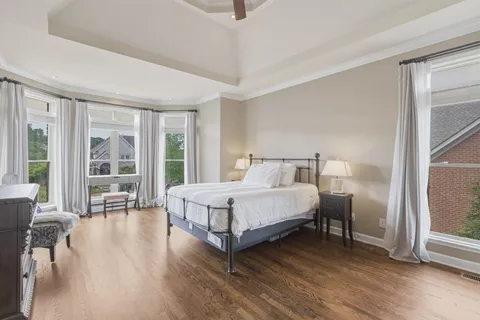 a bedroom with a bed a mirror and a large window