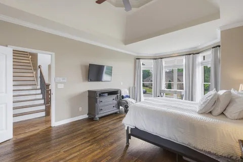 a bedroom with a bed and large windows