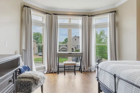 a bedroom with a bed and a couch next to a window