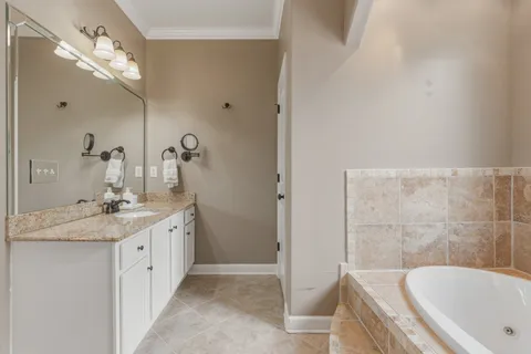 a bathroom with a tub sink and mirror
