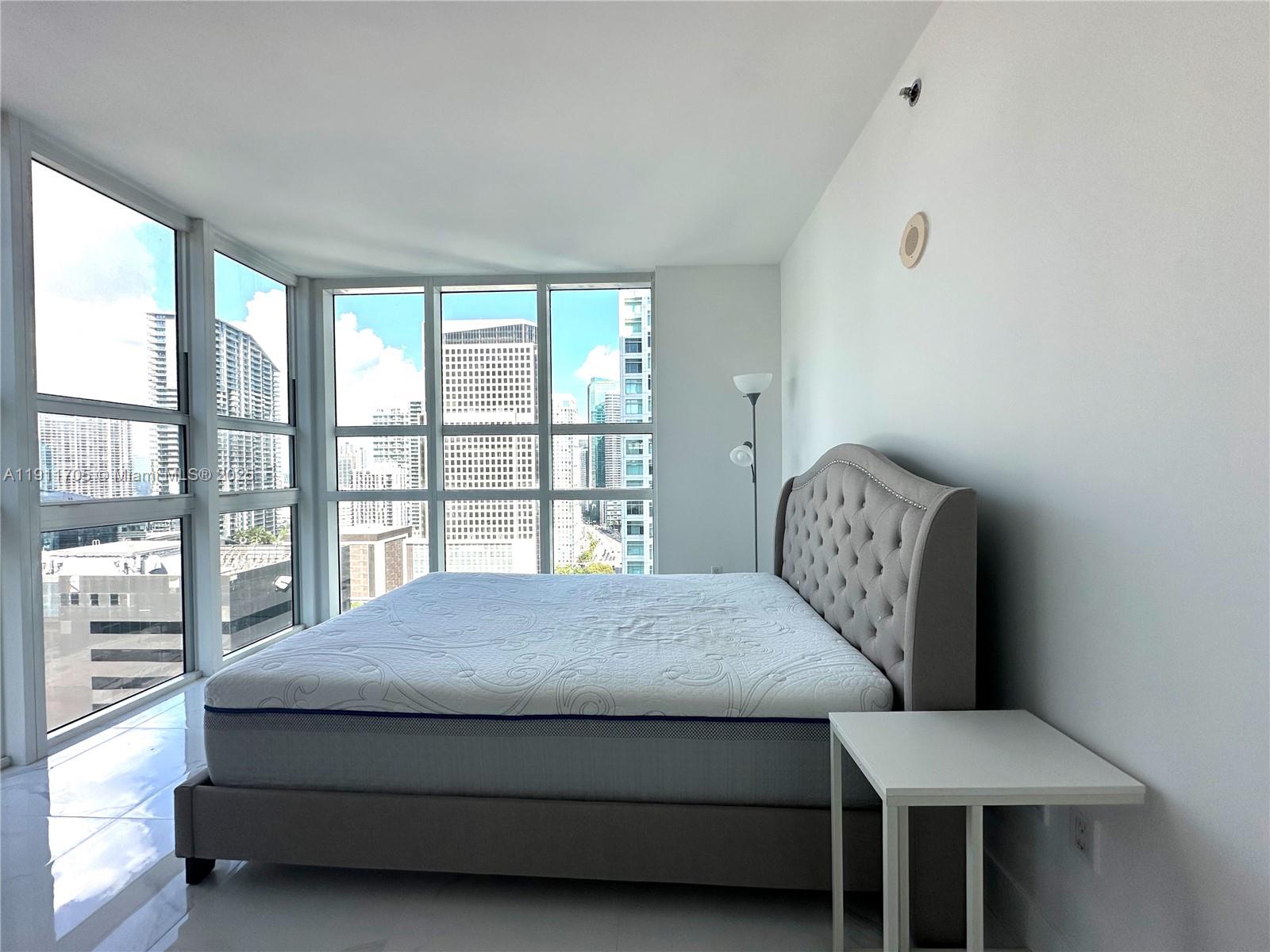 951 Brickell Avenue, Unit 2601 Miami, FL 33131 - Photo 11 of 21 a bedroom with a bed chair and a large window