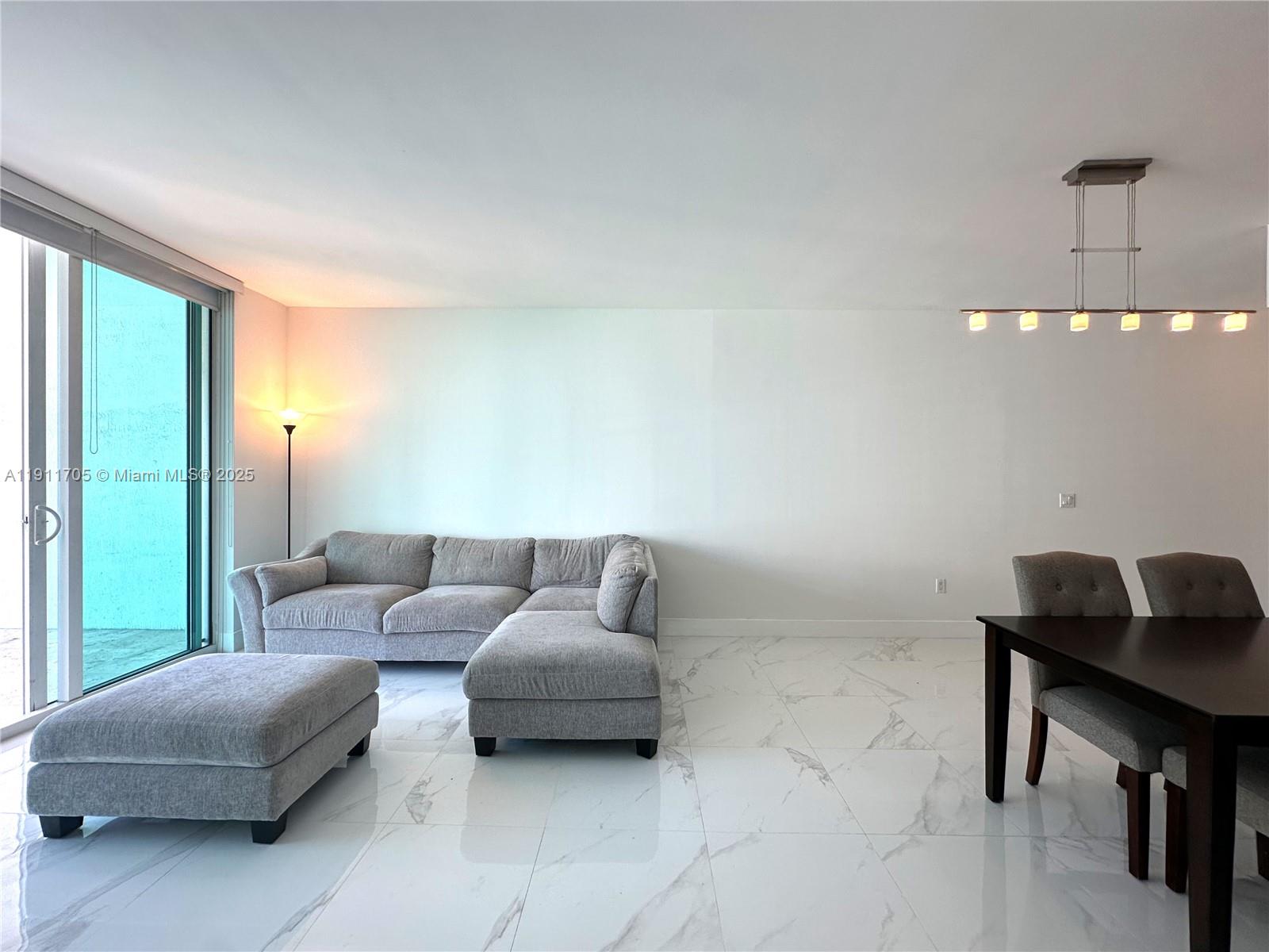 951 Brickell Avenue, Unit 2601 Miami, FL 33131 - Photo 2 of 21 a living room with furniture and a window