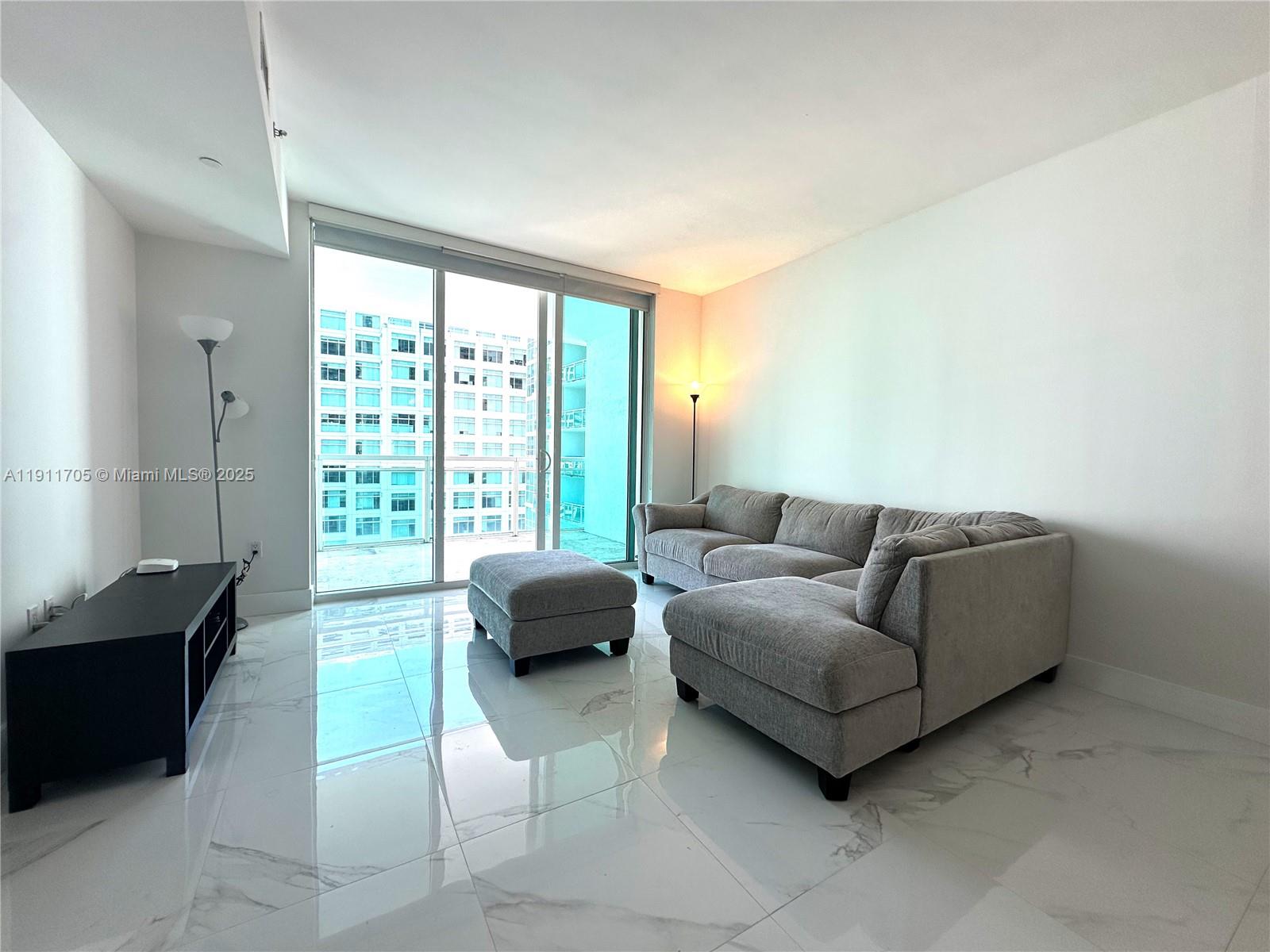 951 Brickell Avenue, Unit 2601 Miami, FL 33131 - Photo 3 of 21 a living room with furniture and a large window