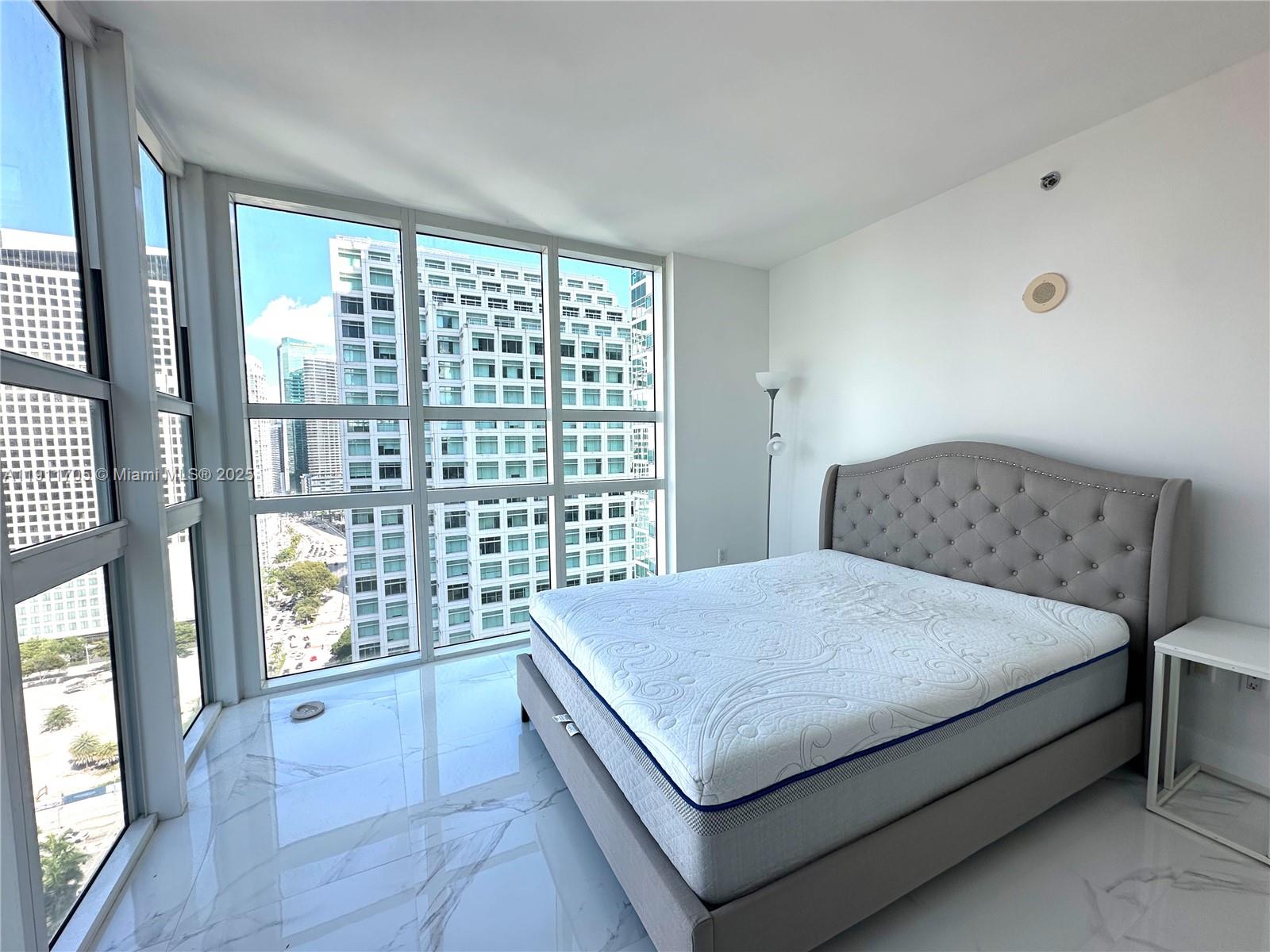 951 Brickell Avenue, Unit 2601 Miami, FL 33131 - Photo 7 of 21 a living room with a bed and next to a window