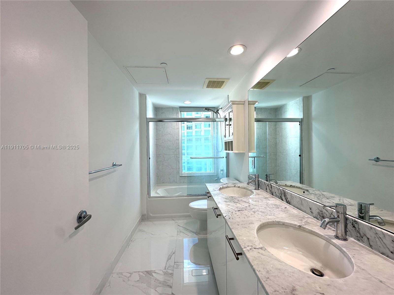 951 Brickell Avenue, Unit 2601 Miami, FL 33131 - Photo 8 of 21 a bathroom with a granite countertop sink a toilet and shower