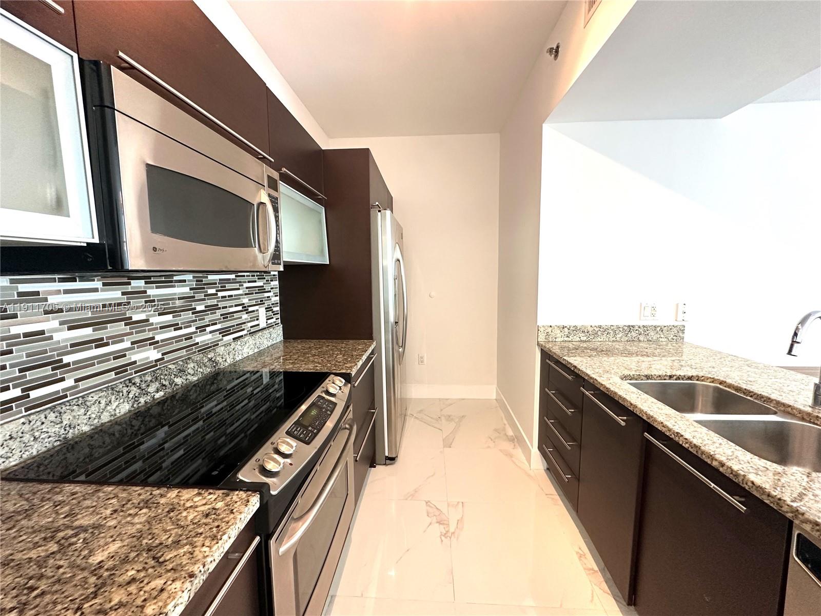 951 Brickell Avenue, Unit 2601 Miami, FL 33131 - Photo 9 of 21 a kitchen with a stove and a microwave