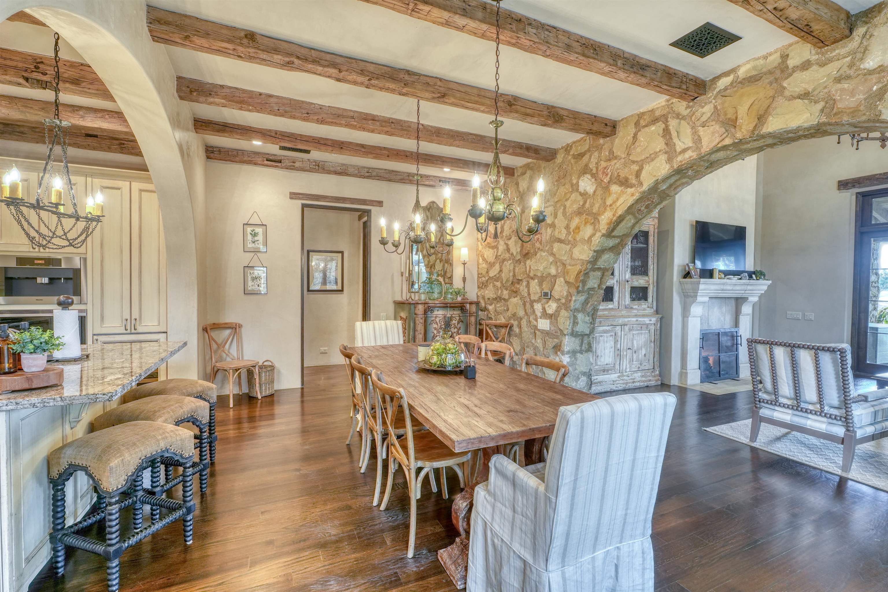 107 Bent Way Road Horseshoe Bay, TX 78657 - Photo 7 of 29 a dining room with wooden floor a chandelier a wooden table and chairs