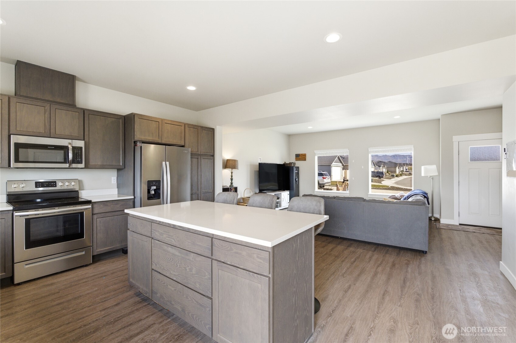 2247 S. Mystical Loop East Wenatchee, WA 98802 - Photo 6 of 25 a large white kitchen with a stove a sink dishwasher and a refrigerator with wooden floor