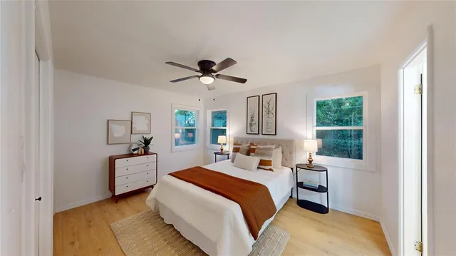 a bedroom with a bed a large window closet and flat screen tv