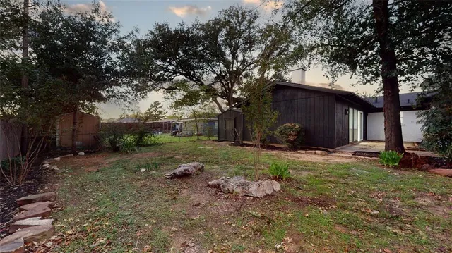 a backyard of a house with outdoor seating and tree