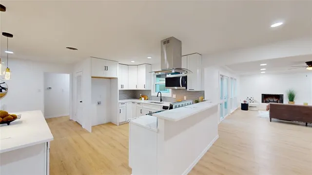 a large white kitchen with stainless steel appliances