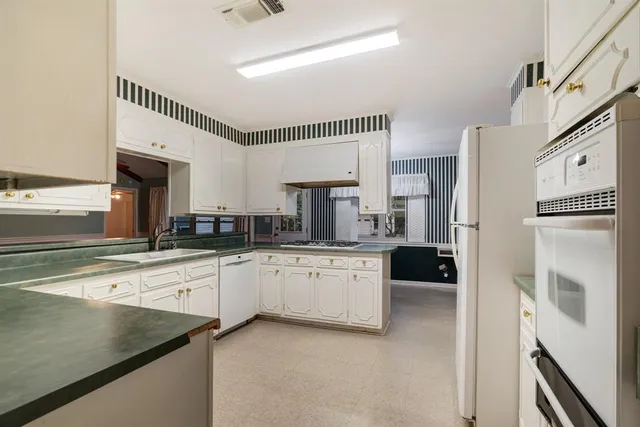 a kitchen with stainless steel appliances a refrigerator sink and cabinets