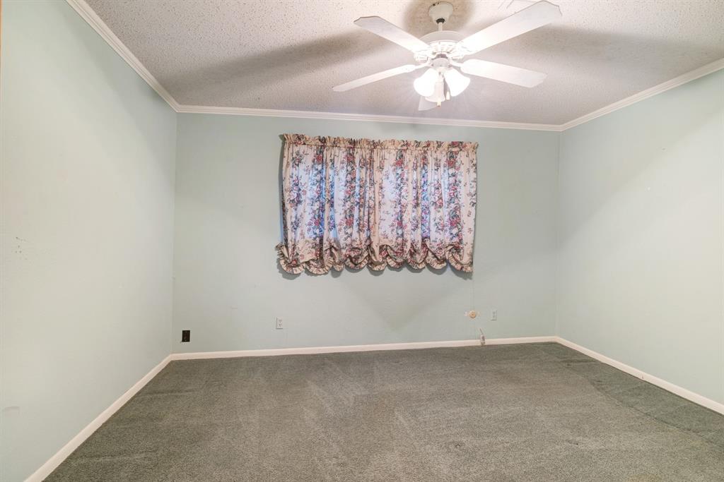 3345 West Kaufman Street Paris, TX 75460 - Photo 10 of 17 an empty room with a window and a ceiling fan