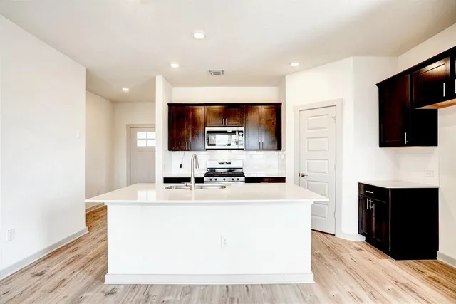 a kitchen with stainless steel appliances a stove microwave and cabinets