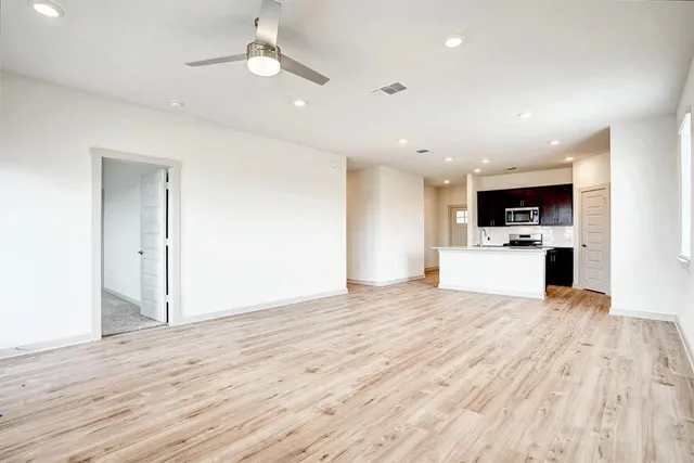 a view of a kitchen with microwave and white cabinets