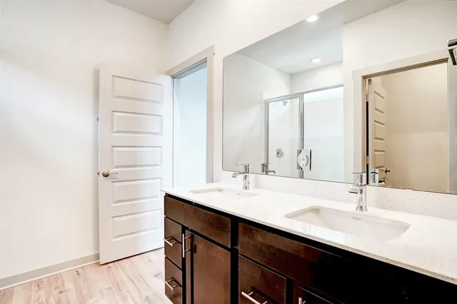 a bathroom with a double vanity sink a mirror and a shower