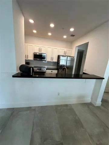a view of kitchen with stainless steel appliances a refrigerator and a stove
