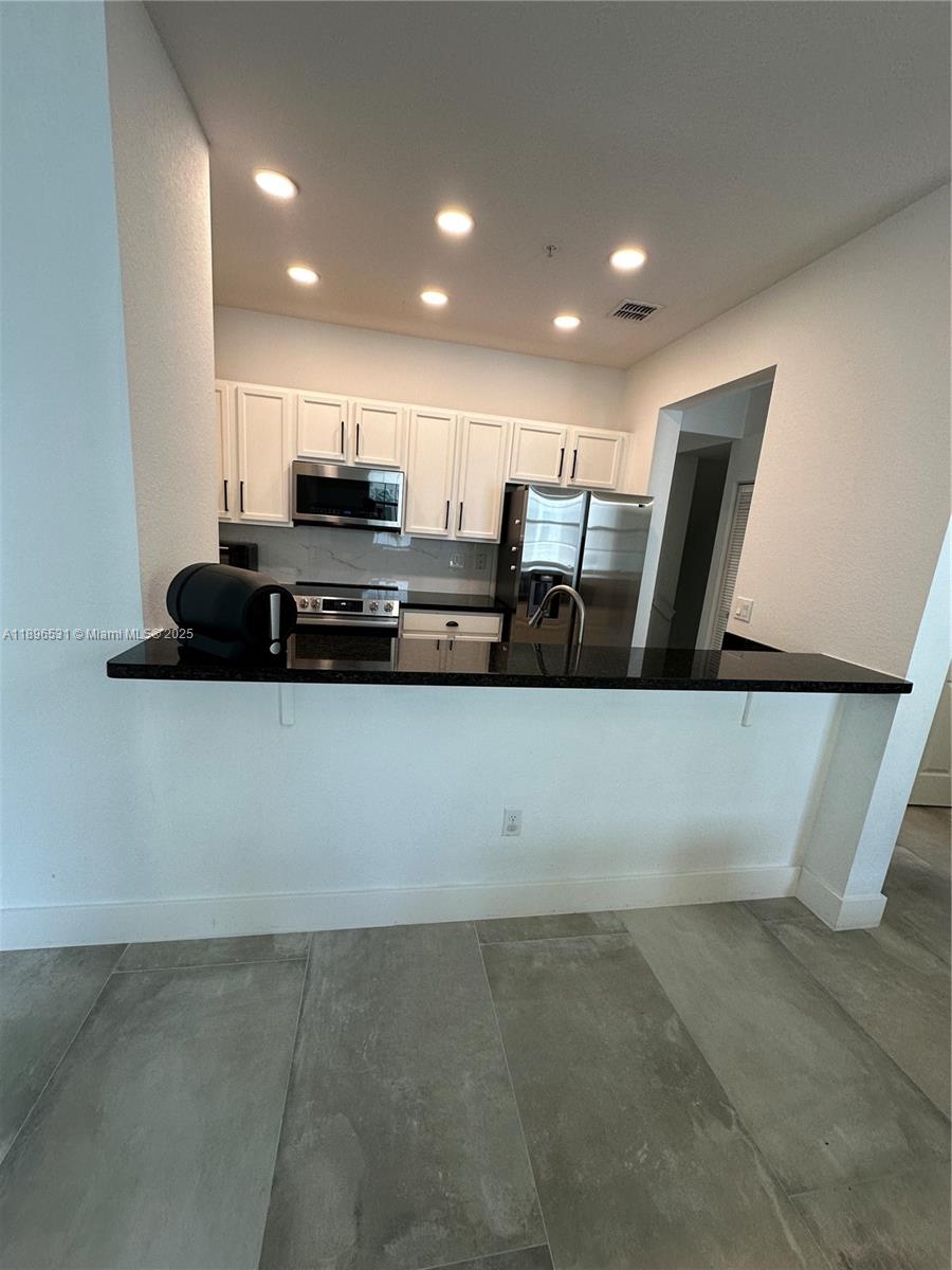 2662 Southwest 118 Road, Unit 2662 Miramar, FL 33025 - Photo 13 of 37 a view of kitchen with stainless steel appliances a refrigerator and a stove