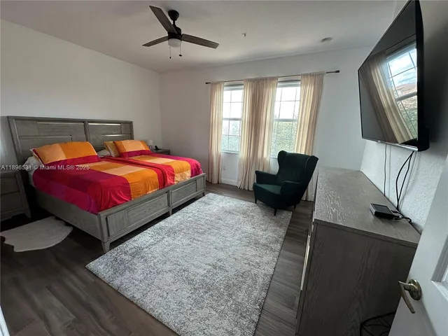 a bedroom with a bed window and a flat screen television