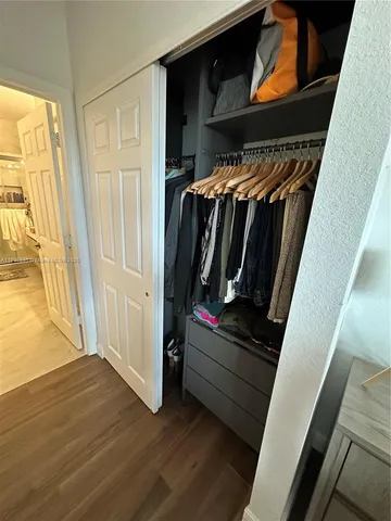 a view of walk in closet with clothes and shoes