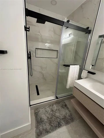 a bathroom with a glass shower door