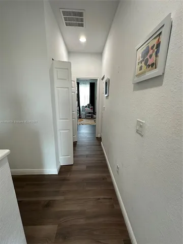a view of a hallway with wooden floor