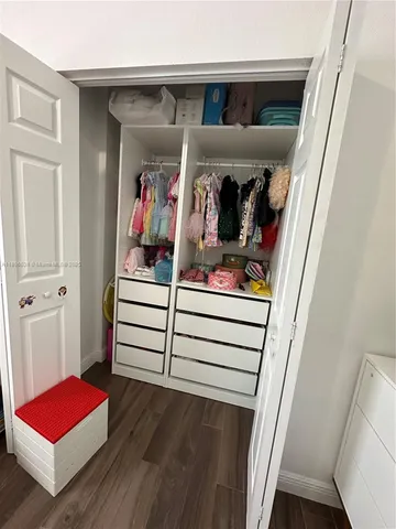 a view of walk in closet with clothes and shoes