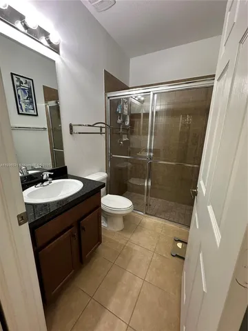 a bathroom with a granite countertop sink toilet and shower