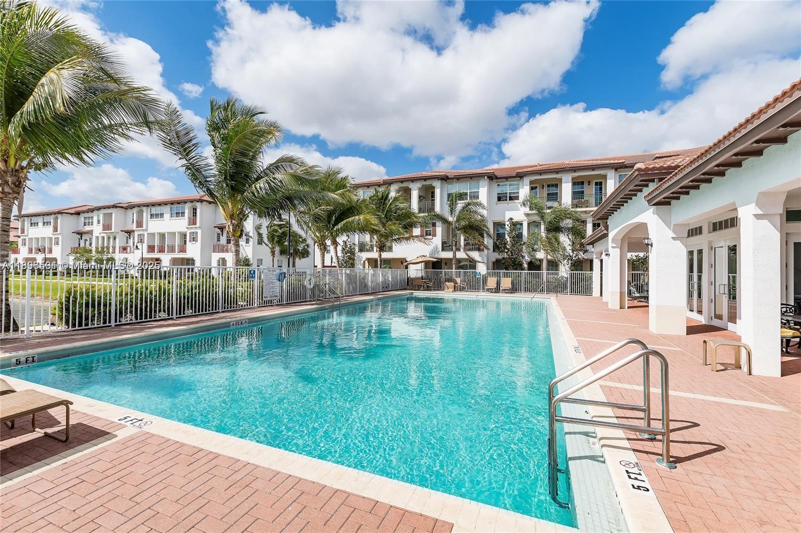 2662 Southwest 118 Road, Unit 2662 Miramar, FL 33025 - Photo 36 of 37 a swimming pool with outdoor seating and yard