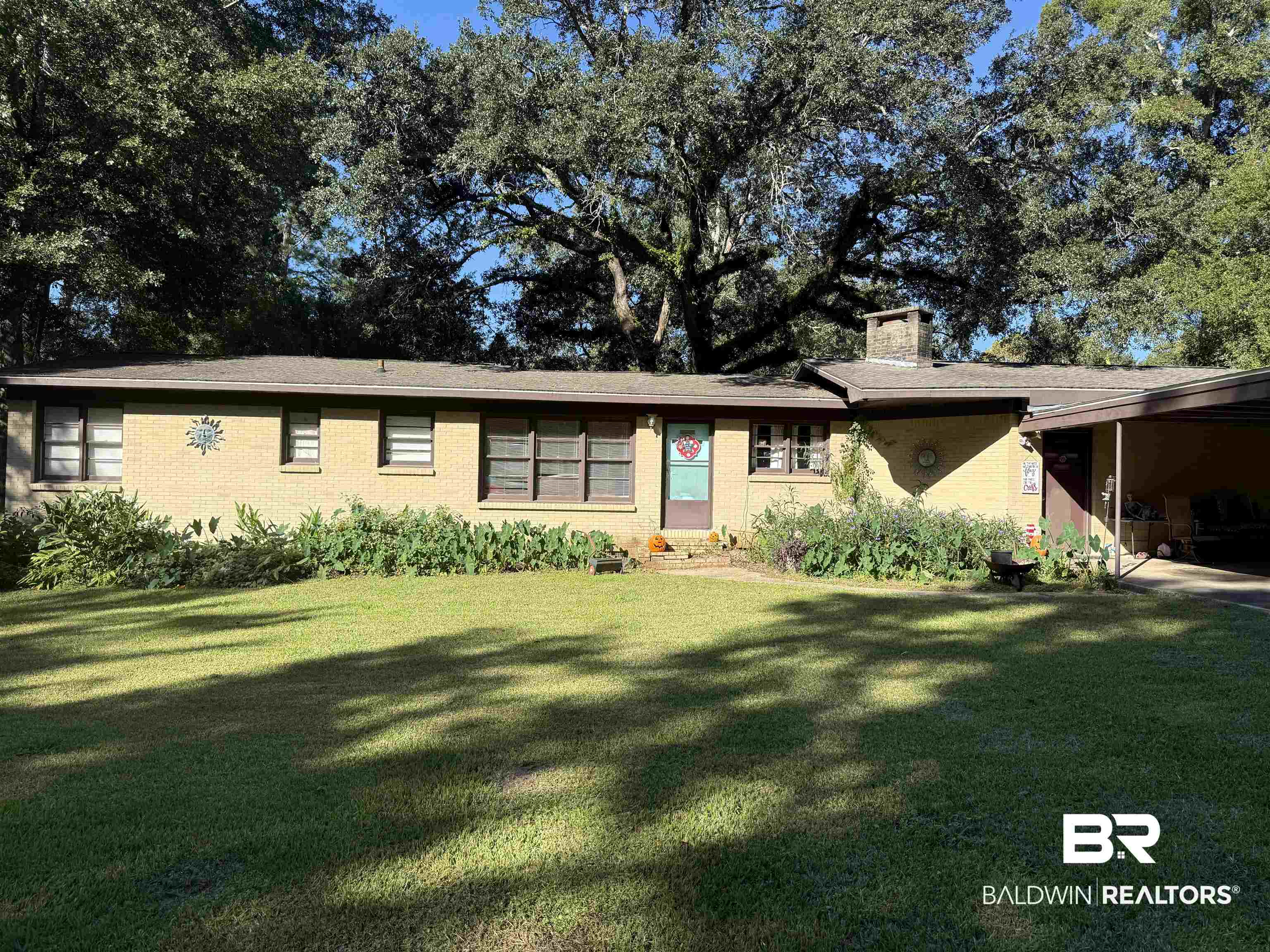 22173 1st Street Silverhill, AL 36576 - Photo 1 of 16 View of front facade featuring a chimney, a front yard, and brick siding