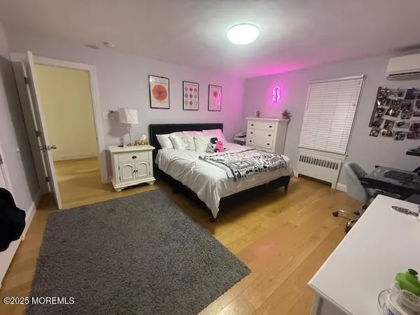a spacious bedroom with a bed and wooden floor