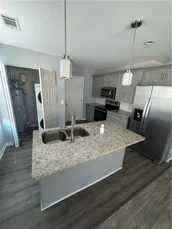 a kitchen with sink refrigerator and microwave