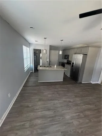 a large room with a bed and wooden floor