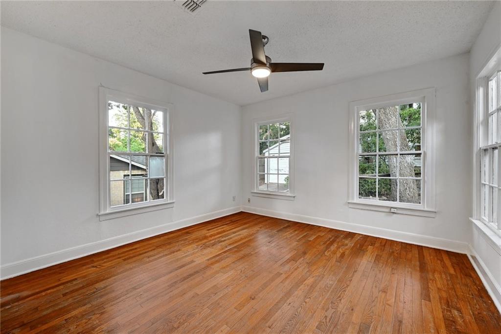 3207 Breeze Terrace, Unit A Austin, TX 78722 - Photo 14 of 18 Secondary bedroom featuring hardwood / wood-style flooring, a textured ceiling, and a ceiling fan