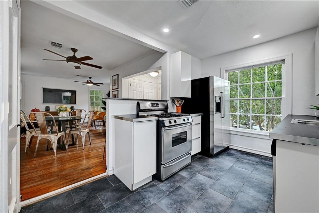 3207 Breeze Terrace, Unit A Austin, TX 78722 - Photo 6 of 18 Kitchen featuring appliances with stainless steel finishes, white cabinets, recessed lighting, and a ceiling fan