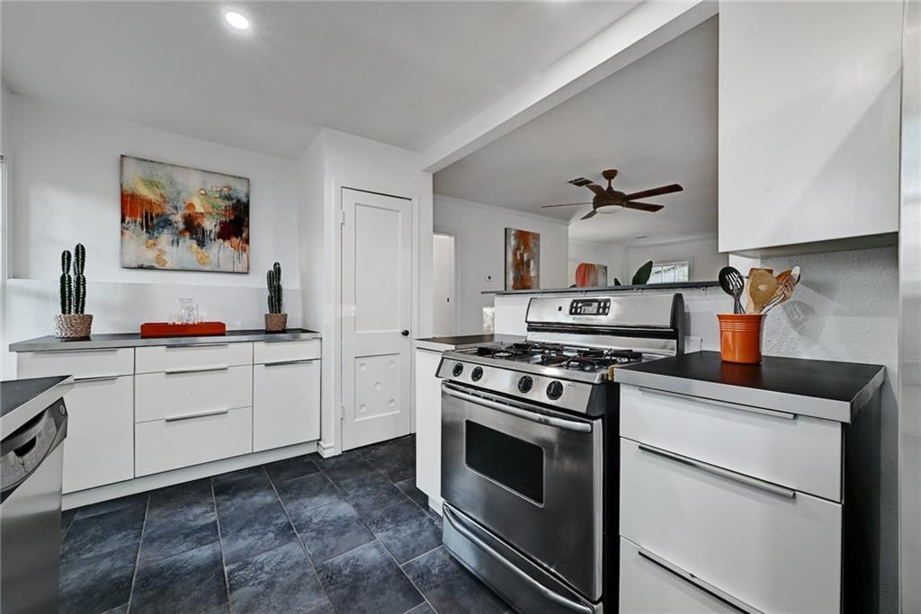 3207 Breeze Terrace, Unit A Austin, TX 78722 - Photo 7 of 18 Kitchen featuring white cabinetry, stainless steel appliances, dark countertops, modern cabinets, and ceiling fan