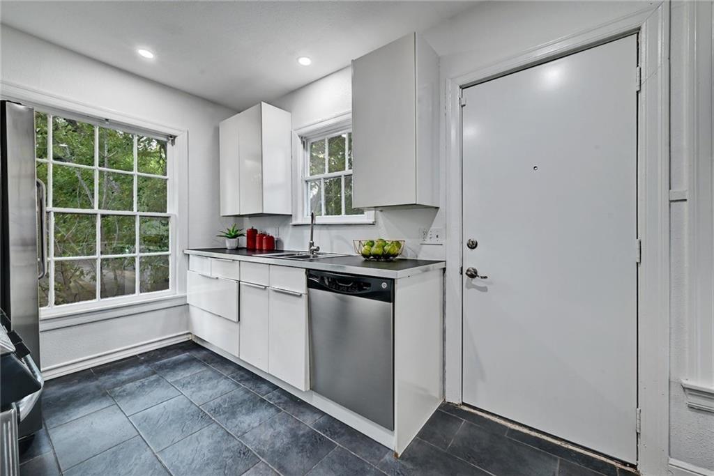 3207 Breeze Terrace, Unit A Austin, TX 78722 - Photo 8 of 18 Kitchen with white cabinets, appliances with stainless steel finishes, and recessed lighting