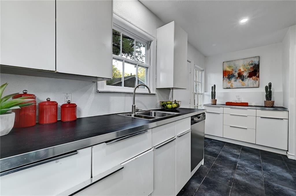 3207 Breeze Terrace, Unit A Austin, TX 78722 - Photo 9 of 18 Kitchen with white cabinets, modern cabinets, dark countertops, recessed lighting, and stainless steel dishwasher