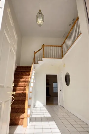 a view of a hallway to a bedroom with wooden floor and staircase
