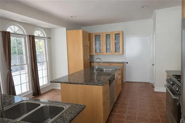 a kitchen with granite countertop a sink stove and cabinets
