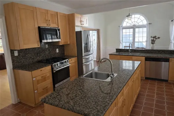 a kitchen with stainless steel appliances granite countertop a sink stove and refrigerator