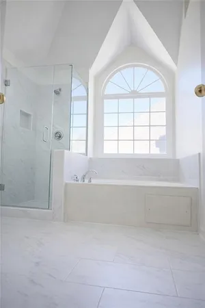 wooden floor with a bathtub in a spacious bathroom