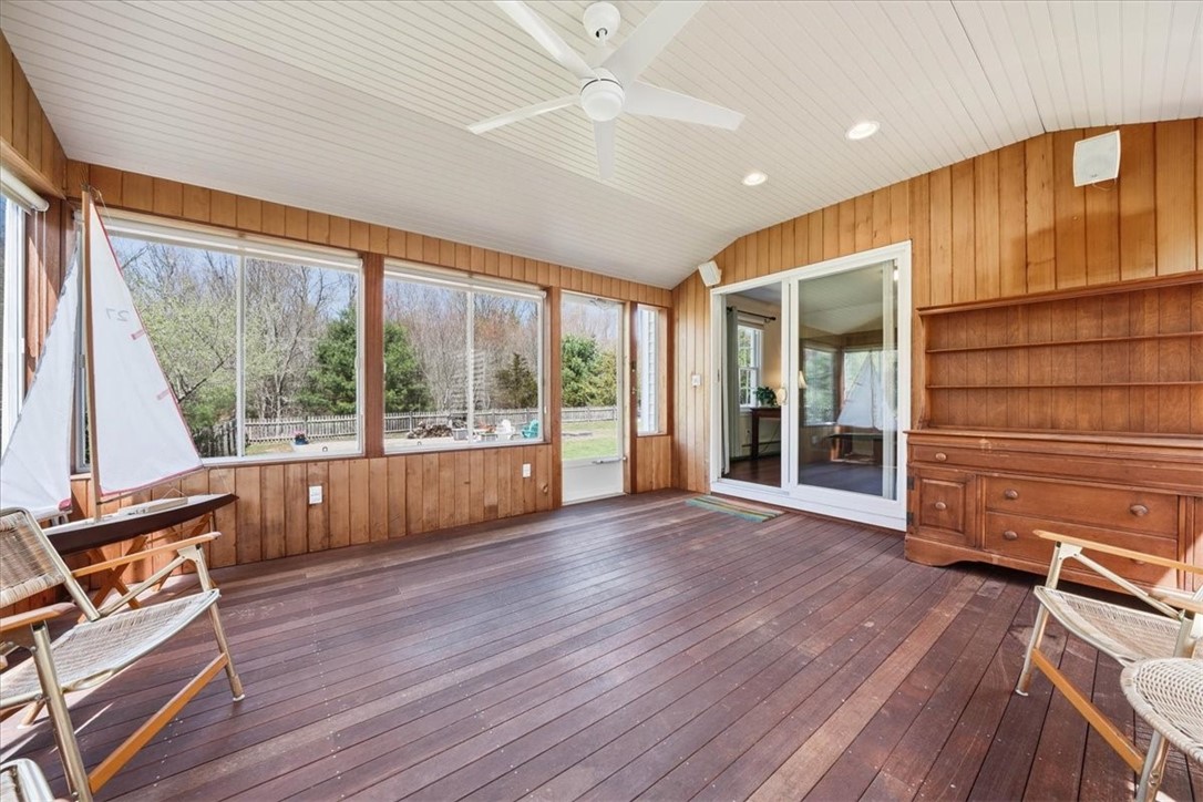 32 Lisa Lane Hopkinton, RI 02832 - Photo 23 of 50 Surrounded by walls of windows, this light-filled retreat invites you to relax, entertain, or unwind while overlooking the private backyard—seamlessly blending indoor comfort with outdoor beauty.