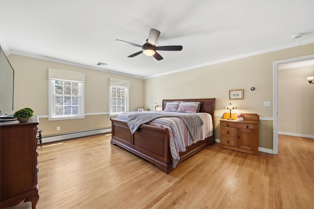 32 Lisa Lane Hopkinton, RI 02832 - Photo 29 of 50 A true sanctuary, this stunning primary suite offers exceptional scale, warmth & versatility. The spacious bedroom w/ hardwood floors is filled w/ natural light & easily accommodates both sleeping & lounging areas. Enjoy a beautifully renovated full bath, along w/ a remarkable dressing corridor featuring dual walk-in closets. Tucked away at the other end is a charming secret bonus space.