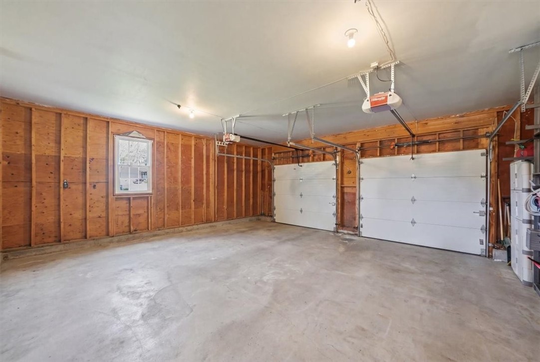 32 Lisa Lane Hopkinton, RI 02832 - Photo 42 of 50 Incredibly spacious attached 2-car garage (528 sf) delivers more than just parking—this oversized area features insulated doors, dual LiftMaster Elite Series openers & abundant room for storage, equipment, hobbies or a workshop setup. A rare find offering true utility & flexibility.