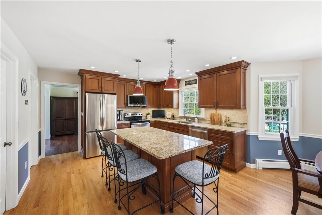 32 Lisa Lane Hopkinton, RI 02832 - Photo 10 of 50 A beautifully renovated kitchen anchors the home, featuring Cherry cabinetry with Harvest Bronze glaze, granite countertops, and an oversized center island with seating—perfect for gathering and entertaining.